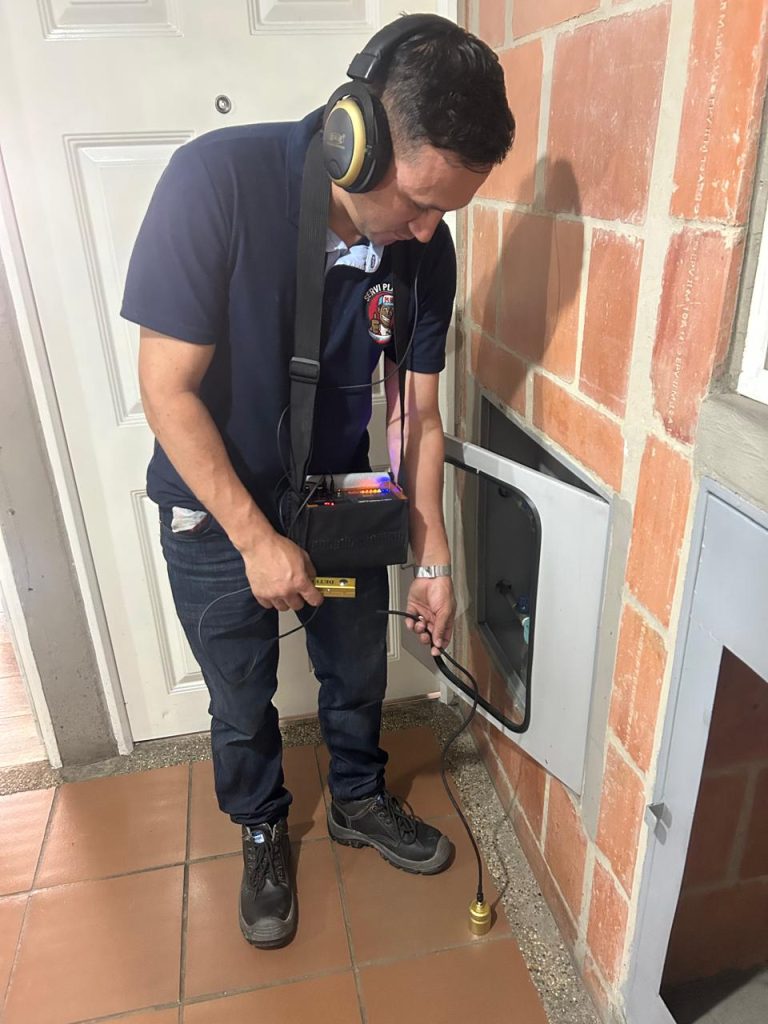 Plomero profesional en Bogotá realizando reparación urgente de tubería